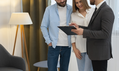 agent-immobilier-masculin-faisant-des-affaires-et-montrant-la-maison-a-un-couple-d-acheteurs-potentiels-scaled.jpg