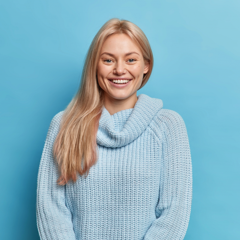 belle-jeune-femme-souriante-aux-cheveux-blonds-exprime-des-emotions-positives-des-dents-blanches-parfaites-habillees-de-pull-chaud-tricote-scaled.jpg