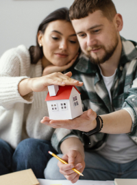 couple-holding-small-house-medium-shot-scaled.jpg