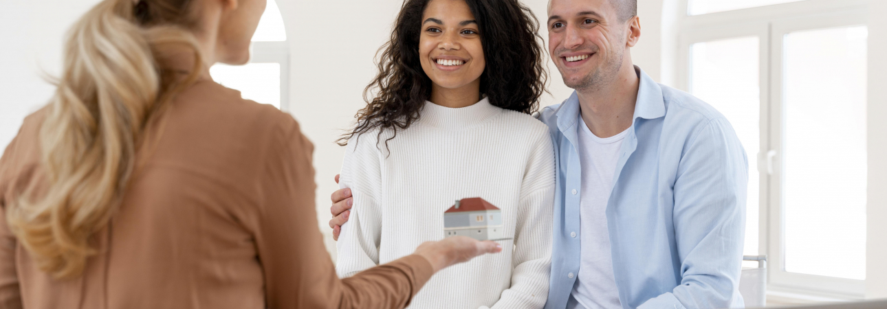 smiley-embrasse-couple-conversant-avec-un-agent-immobilier-feminin-scaled.jpg